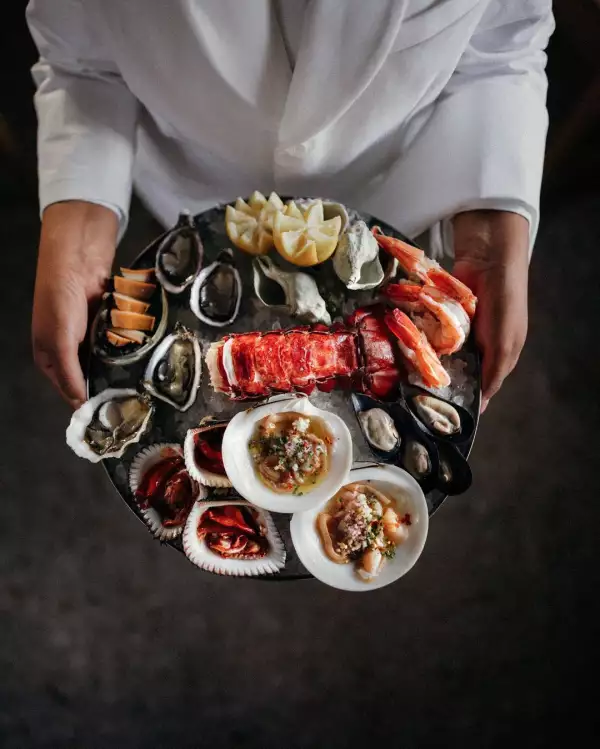 Foto de un platillo lleno de pescados y conchas listos para servirse en la mesa del restaurante.