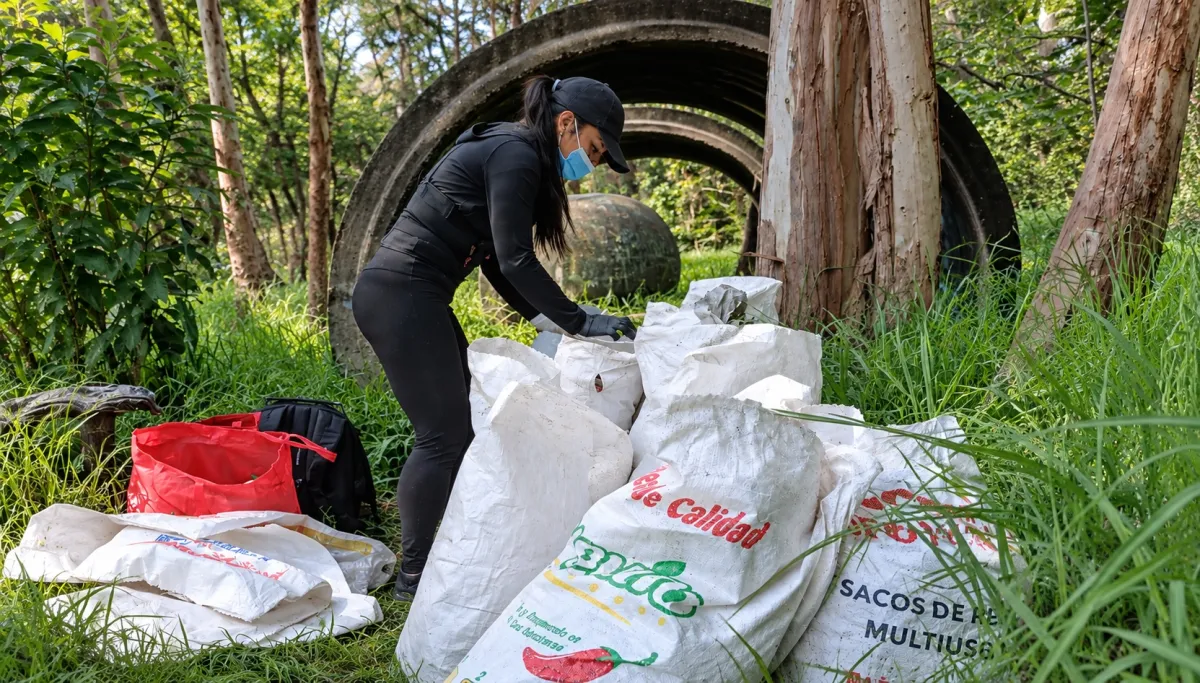 Personas separan residuos en bolsas durante una jornada de recolección de basura en el Bosque de Chapultepec, en Ciudad de México.
