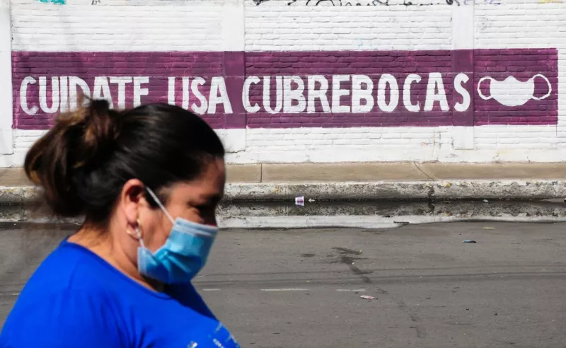 Una mujer camina por una de las calles de la colonia Carlos Zapata Vela en la Alcaldía Iztacalco, la cual ha registrado un alto número de casos por Covid-19.