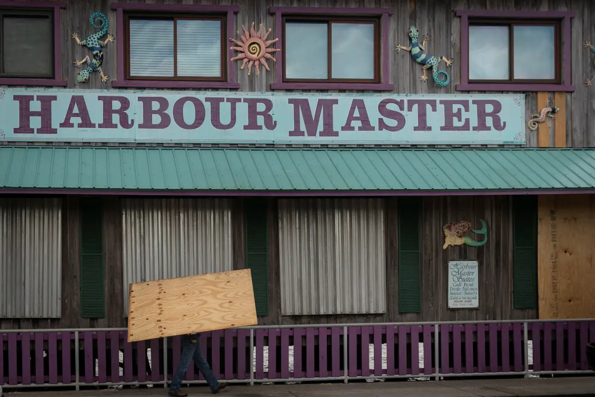 Un hombre coloca madera contrachapada frente a una tienda antes de la llegada del huracán Idalia en Cedar Key, Florida, EE. UU., el 29 de agosto de 2023.