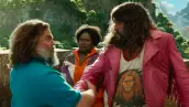 Foto de una escena de 'Una película de Minecraft' con Jack Black y Jason Momoa viéndose de frente con expresión de luchar y detrás los observa extrañada Danielle Brooks.