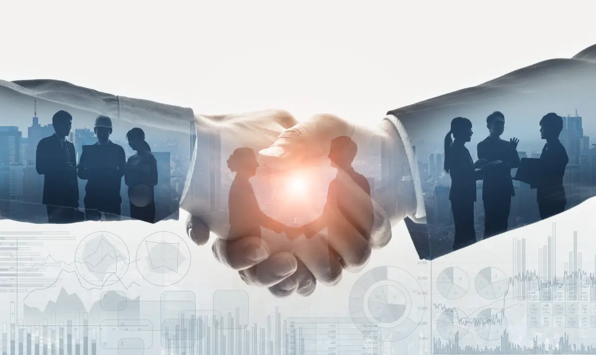 Grupo de personas de negocios de fondo a un apretón de mano entre socios, con fondo iluminado 