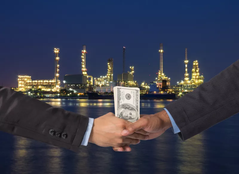 Hand shake between a businessman with dollar money on Petrochemi