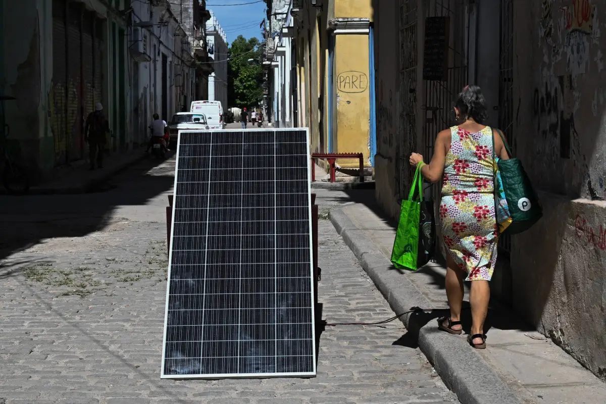 Una mujer pasa junto a un panel solar durante un corte de energía a nivel nacional en La Habana el 6 de julio de 2026.