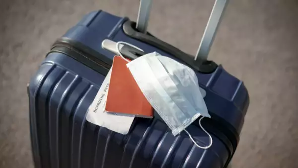 suitcase, passport and medical mask
