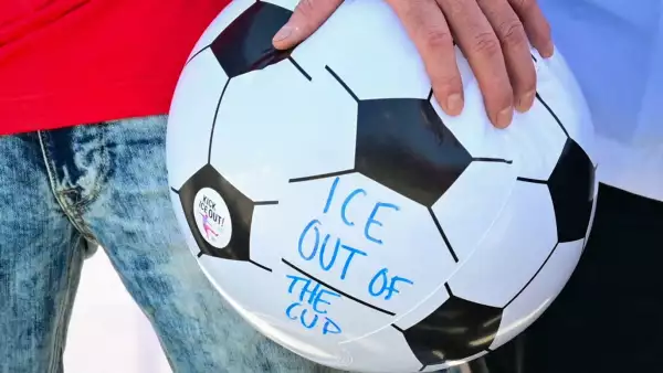 Un hombre sostiene una pelota con el mensaje "ICE fuera de la copa" mientras está de pie con los trabajadores del estadio SoFi representados por Unite Here 11 durante una conferencia de prensa sobre una actualización de las negociaciones de contrato en el estadio SoFi en Inglewood, California, el 9 de junio de 2026.