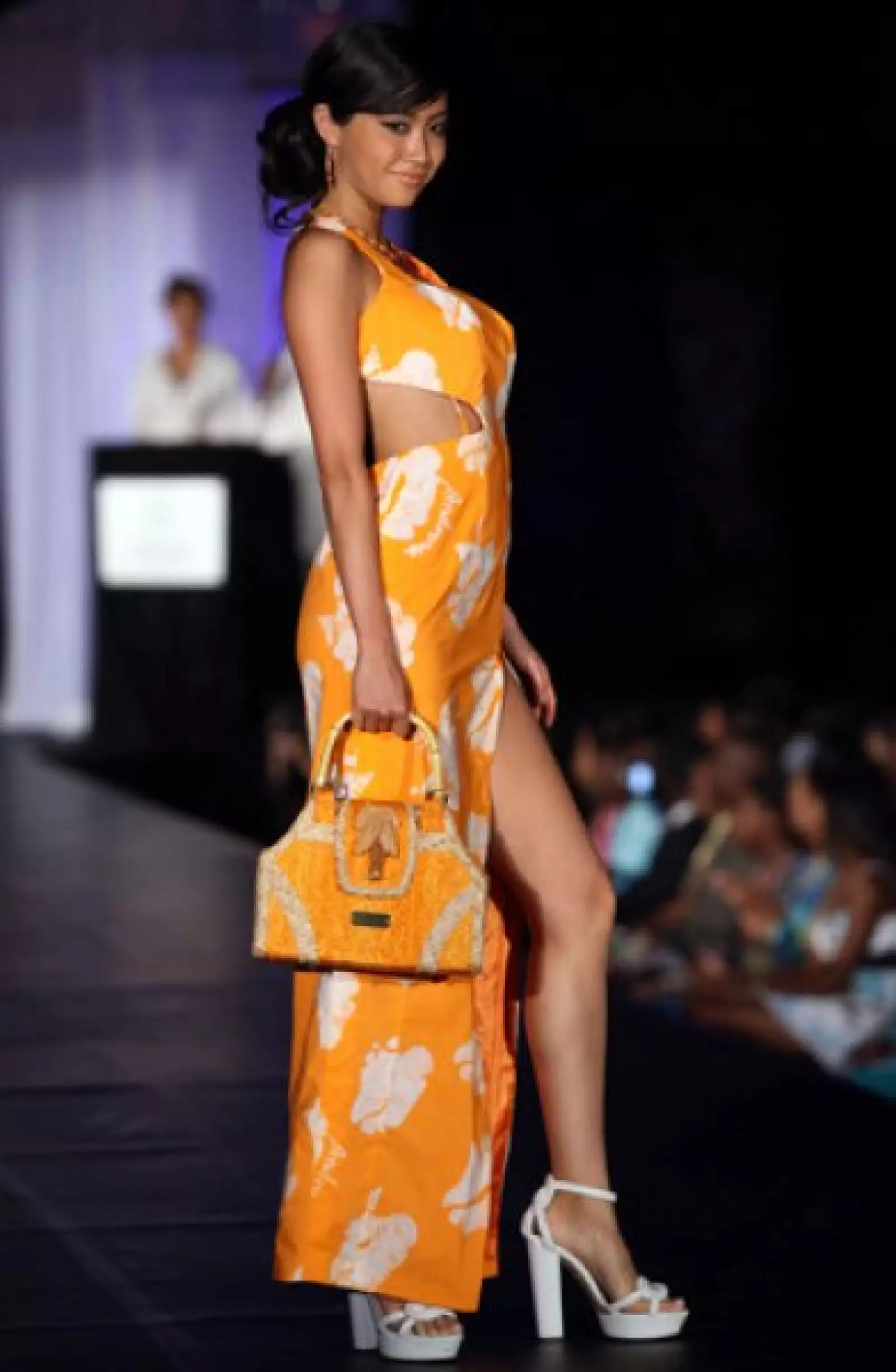 Emiri Miyasaka, de Japón, se veía muy coqueta en este vestido naranja con blanco, además de una pequeña bolsa en el mismo tono. Los zapatos fueron blancos de plataforma que hiciero juego con las flores del atuendo.