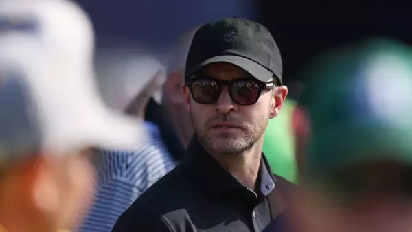 foto de archivo de justin timberlake vistiendo una playera tipo polo negra, con lentes oscuros y gorra negra.