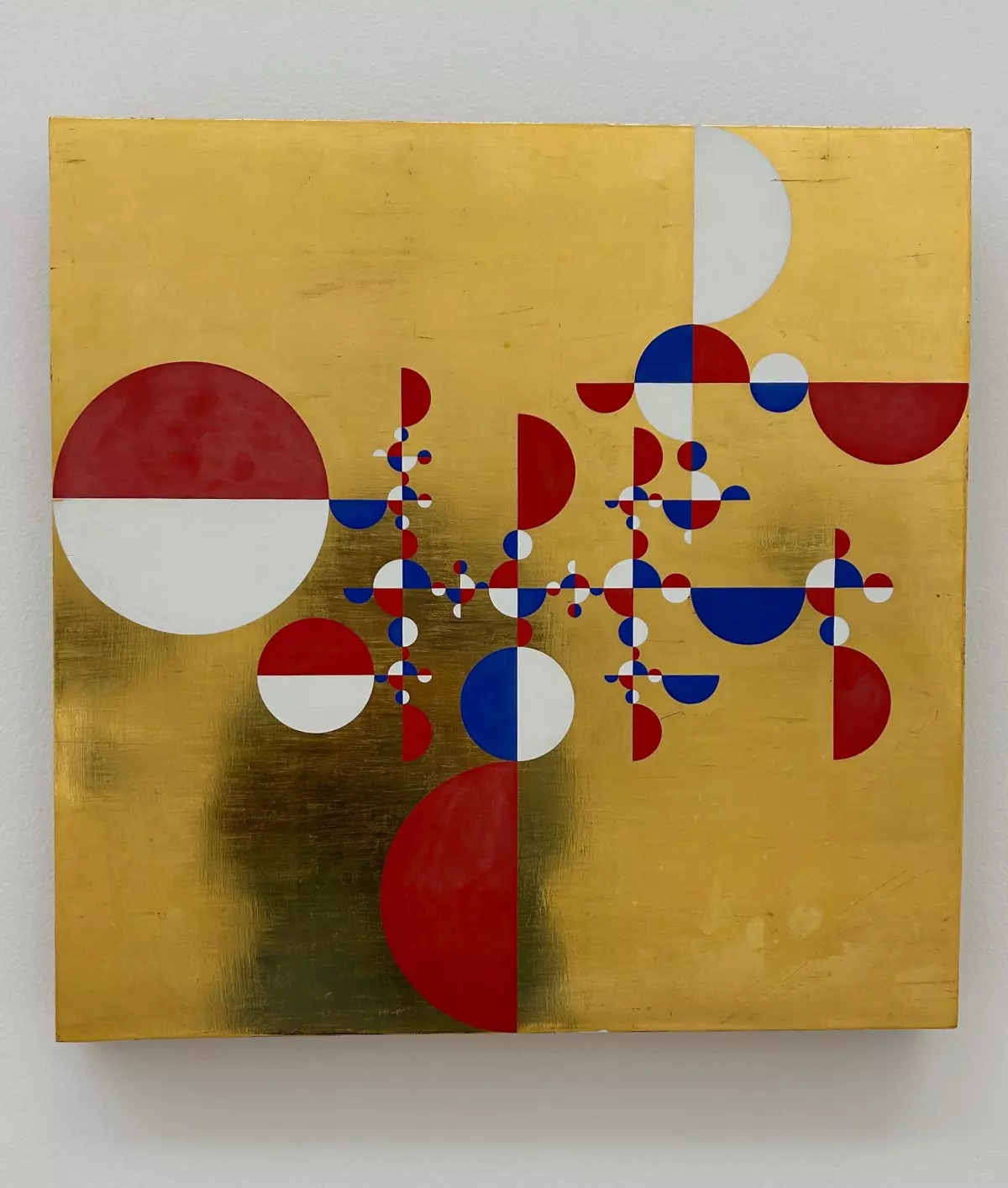 Foto de una obra de Gabriel Orozco: un cuadro de fondo dorado con círculos divididos a la mitad pintados de distintos colores (rojo, blanco y azul).