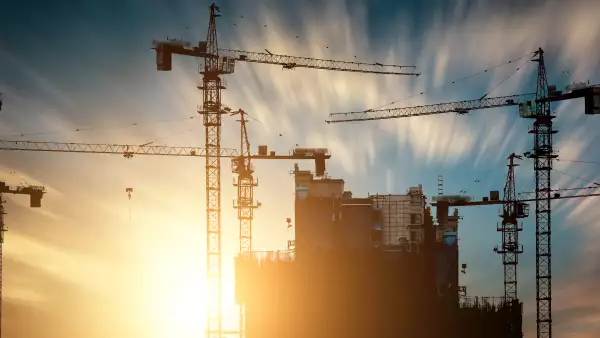 Construction cranes at sunset