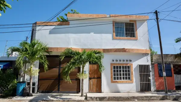 Fotografía de la fachada de una casa blanca en una calle de Tulum, Riviera Maya. 