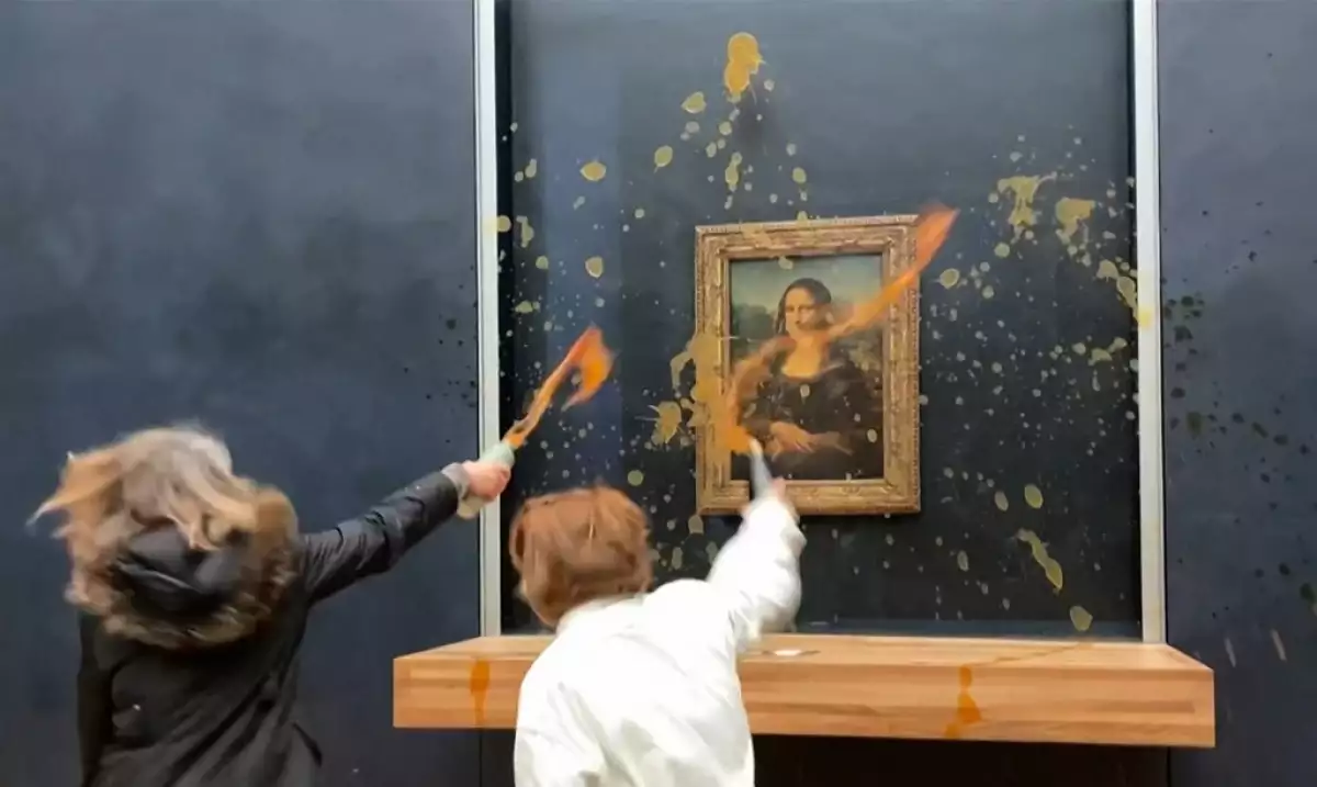 Esta imagen tomada de imágenes de AFPTV muestra a dos activistas ambientales del colectivo apodado "Riposte Alimentaire" (Represaliación de alimentos) lanzando sopa en la pintura "Mona Lisa" (La Joconde) de Leonardo Da Vinci, en el museo del Louvre en París, el 28 de enero de 2024.