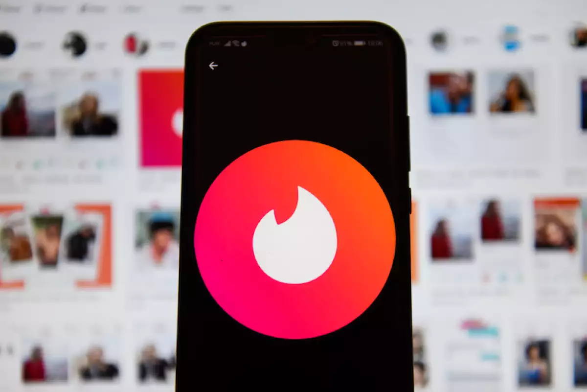 In this photo illustration a Tinder logo seen displayed on a