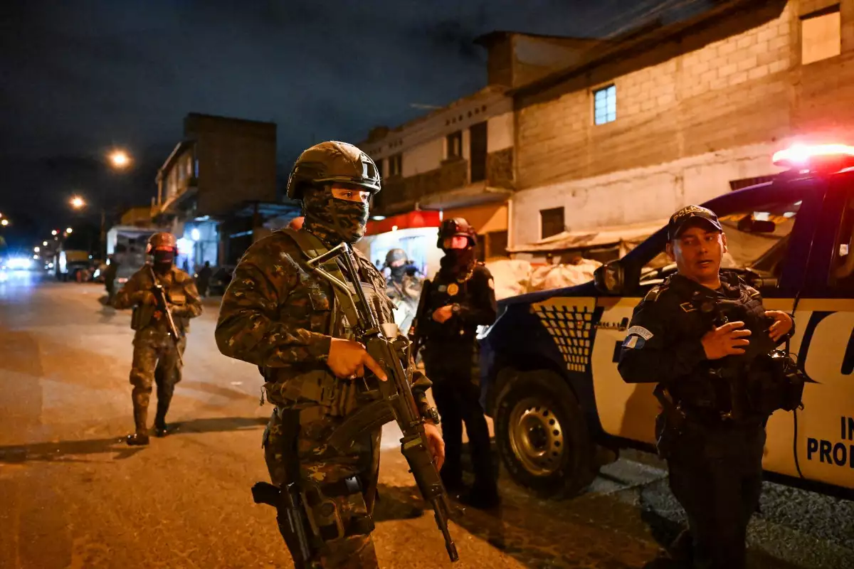 Soldados del ejército guatemalteco y oficiales de policía patrullan una calle del barrio Manuel Colom Argueta durante el estado de emergencia declarado por el gobierno en la Ciudad de Guatemala el 22 de enero de 2026.