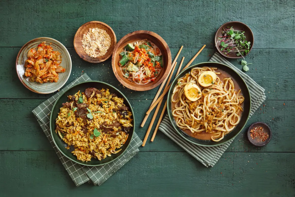 Fideos Dan Dan. Arroz frito con ternera al curry al estilo coreano. Foto de arriba hacia abajo sobre fondo verde oscuro.