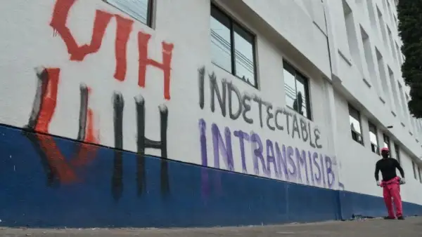 En la imagen se oberva una pared pintada con la leyenda: "VIH indetectable. VIH intransmisible". 