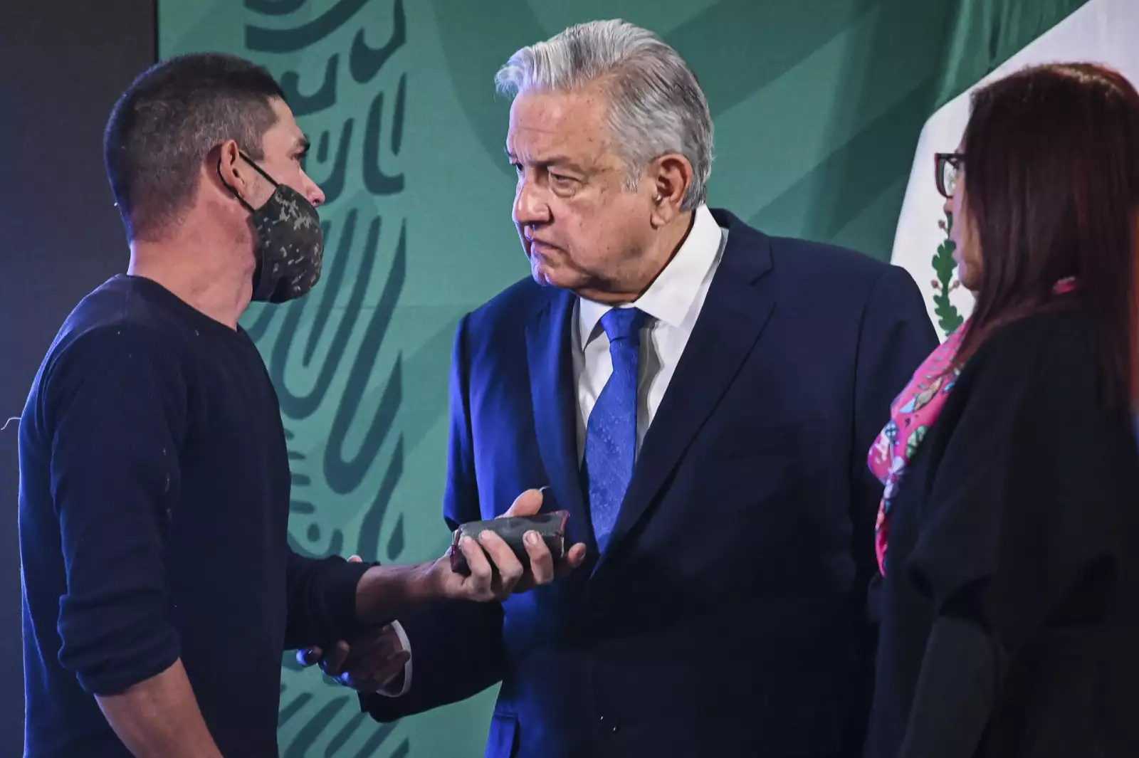 La persona que se coló a la conferencia mañanera del presidente de México, Andrés Manuel López Obrador, intentó darle algo cuando se acercó a él.