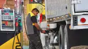 Un despachador de combustible en una gasolinera despacha diésel, un combustible fósil que podría sustituirse por biodiésel.