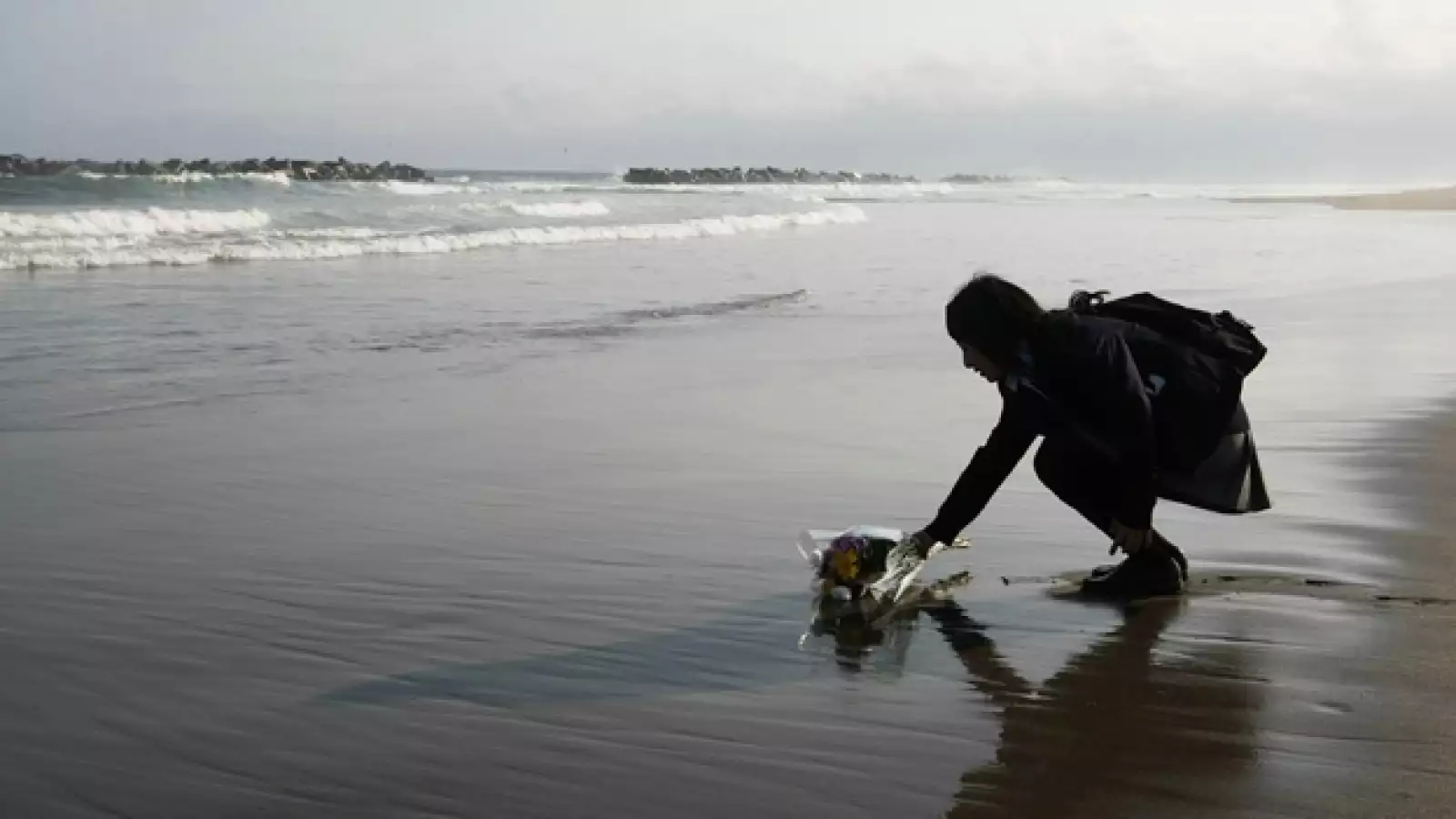 Mai Otomo, joven de 17 años, deja flores ante el mar