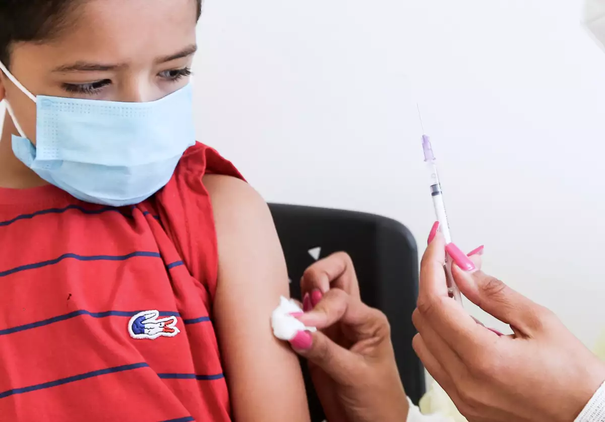 (Niño a punto de ser vacunado contra Covid-19)