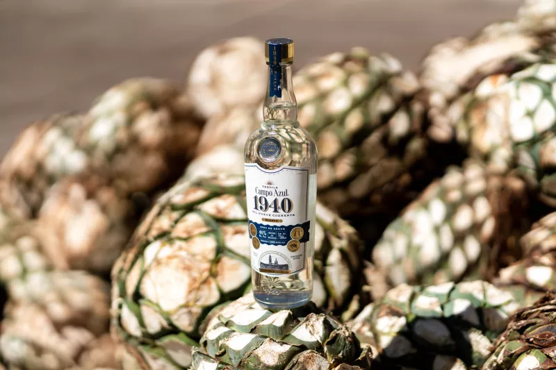 Botella de Tequila Campo Azul 1940, en un campo de agave. 