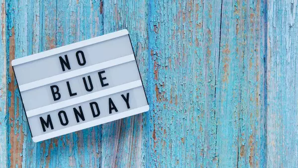 Blue monday day banner concept. White board with text no blue monday on blue wooden background, top view, flat lay. Copy space.
