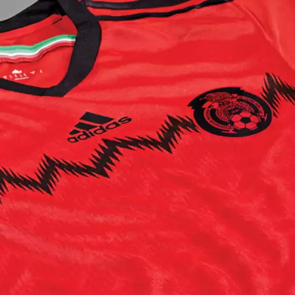 El escudo de la FMF se encuentra ubicado a la altura del corazón en una aplicación dicromática. Debajo de él se encuentra un gráfico de grecas negras que se repite en tonos rojos de manera sutil en la parte frontal.