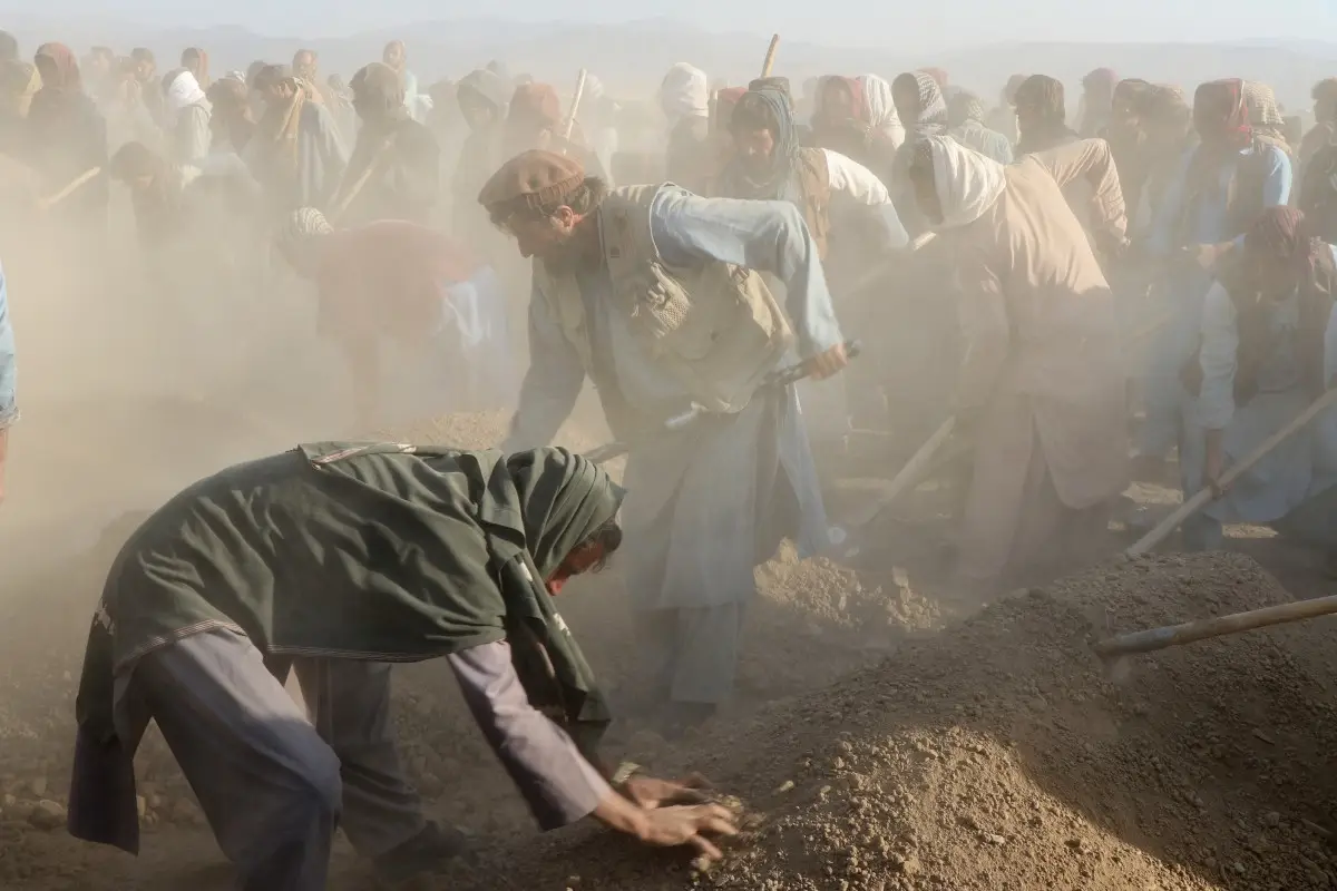 Los dolientes afganos y los familiares de las víctimas cubren las tumbas con tierra durante una ceremonia de entierro masivo de nueve niños y una mujer que murieron en un ataque aéreo de Pakistán, en el distrito de Gurbuz, en la provincia de Khost, el 25 de noviembre de 2025. El gobierno talibán de Afganistán prometió el 25 de noviembre "responder adecuadamente" a los ataques nocturnos que culpó al vecino Pakistán que mataron a 10 personas, ya que las tensiones aumentaron el día después de un atentado suicida en una ciudad pakistaní.