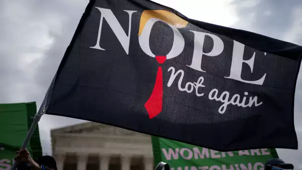 Una persona ondea una bandera mientras activistas de la Marcha de las Mujeres realizan una manifestación “Feministas contra Fascistas” mientras los jueces de la Corte Suprema escuchan argumentos sobre el reclamo de inmunidad presidencial del expresidente Trump por cargos penales por sus esfuerzos por anular los resultados de las elecciones presidenciales de 2020 fuera de la Corte Suprema de Estados Unidos. Tribunal de Washington, Estados Unidos, 25 de abril de 2024.