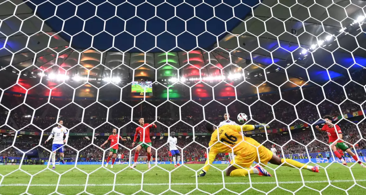 Foto detrás de la portería en donde se ve a Vitinha, de Portugal, cobrar un penal contra Francia y el portero Mike Maignan para el balón.