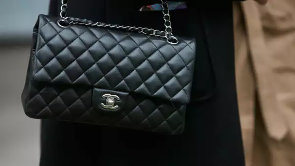 Woman with black Chanel leather bag with silver chain