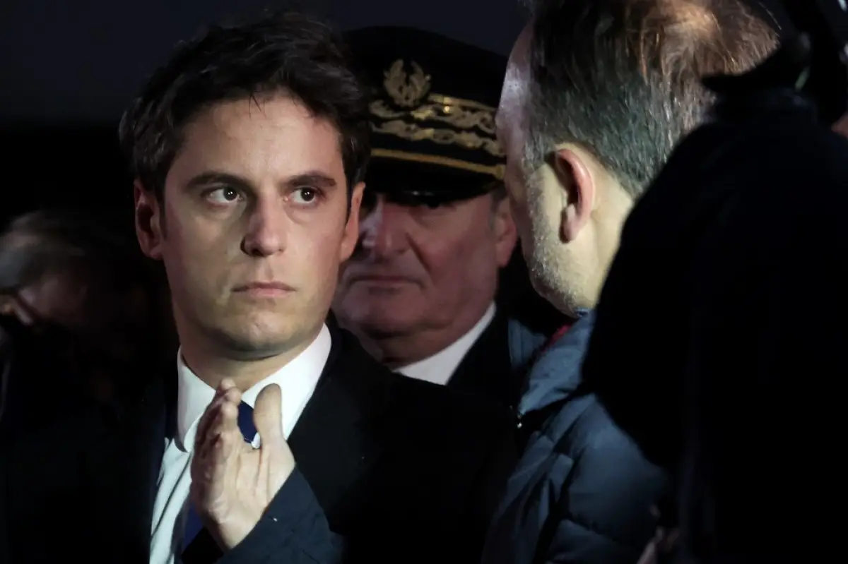 El recién nombrado primer ministro francés, Gabriel Attal (i.), flanqueado por el prefecto del distrito de Pas-de-Calais, Jacques Billant (C), recorre Clairmarais, al norte de Francia, el 9 de enero de 2024. 