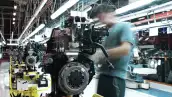 Un trabajador participa en la colocación de tornillos para la fabricación de un motor en una planta de autopartes en México. 
