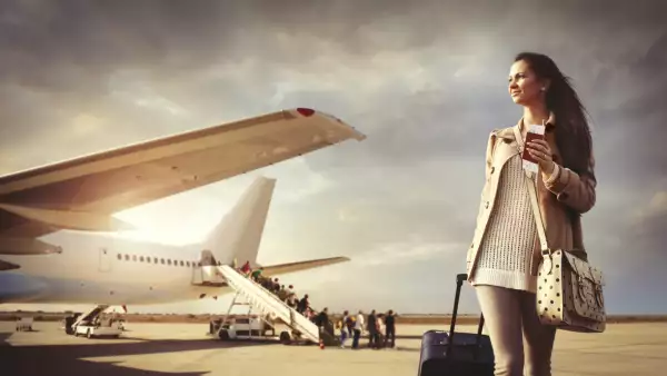 Young woman with suitcase arrived at the airport