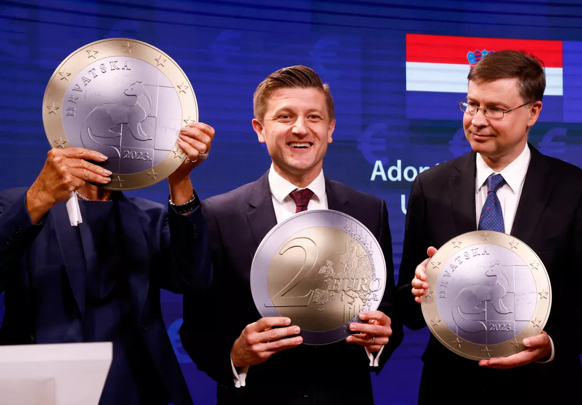 El ministro de Finanzas de Croacia, Zdravko Maric, el vicepresidente del comisario europeo, Valdis Dombrovskis, y la presidenta del Banco Central Europeo, Christine Lagarde, posan con un modelo de una moneda de euro después de una ceremonia de firma sobre la adopción del euro por parte de Croacia en Bruselas, Bélgica, el 12 de julio de 2022. 