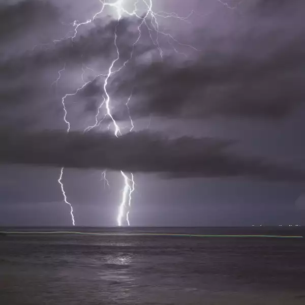 Una pequeña embarcación deja un rastro de luz en el mar para después cruzar la frontera de forma presuntamente ilegal.