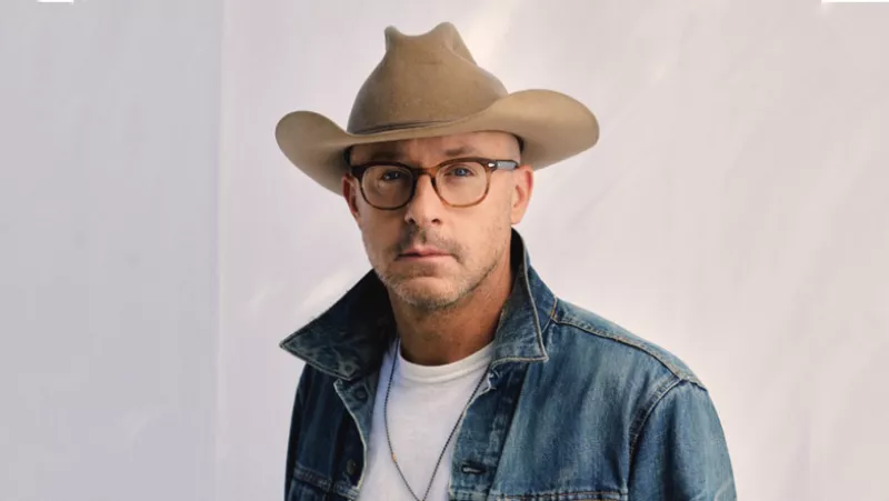 Mark Avery stylist de ryan gosling con lentes, chamarra de mezclilla y sombrero