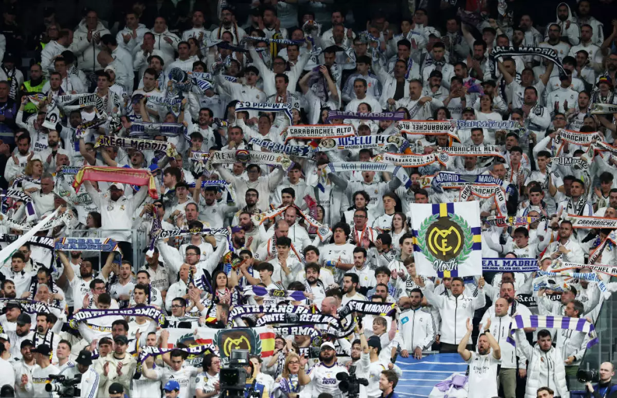 Foto de los aficionados del Real Madrid en las gradas apoyando a su equipo.