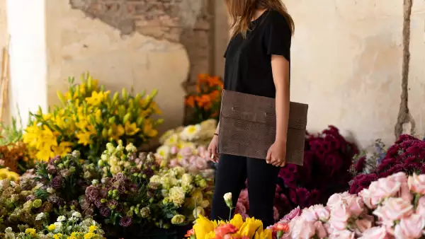 Mujer sosteniendo un porta laptop de piel.