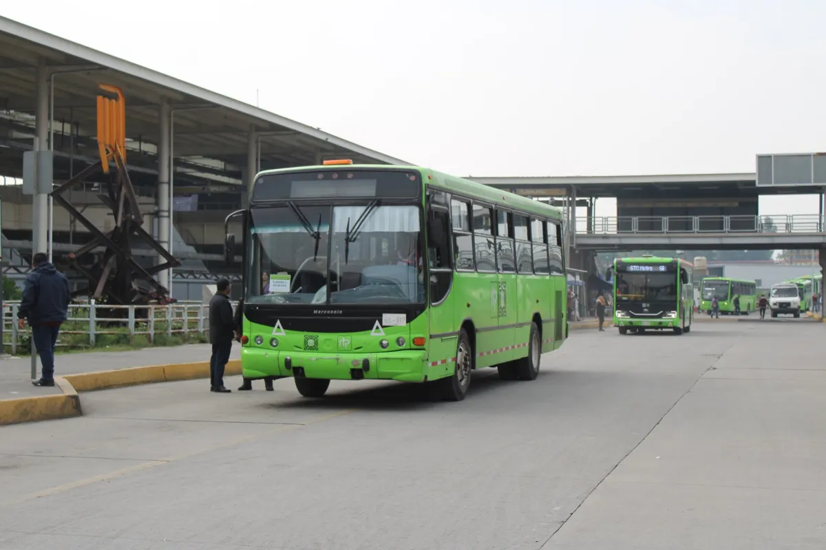 Autobús verde de la Red de Transporte de Pasajeros (RTP) de la Ciudad de México circulando dentro de una terminal, con otras unidades al fondo.
