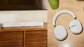 Imagen dividida en dos. Del lado de la izquierda, la nueva barra de sonido Beam Ultra en color blanco debajo de un televisor y, del lado derecho, los nuevos audífonos Ace Ultra en primer plano.