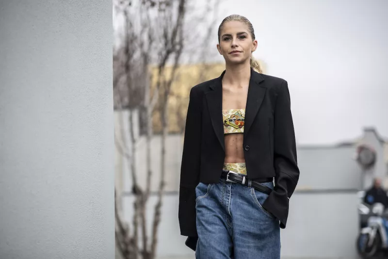 Mujer con top colorido y blazer negro. 
