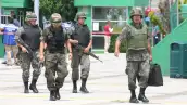 Cuatro elementos de las Fuerzas Armadas caminan con armas tras amenaza de bomba en Morelia durante las fiestas patrias de 2008. 