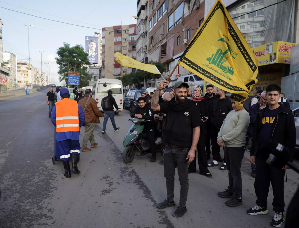 Un hombre sostiene una bandera de Hezbolá, antes de la llegada del Papa León XIV al Líbano durante su primer viaje apostólico, en Haret Hreik, los suburbios del sur de Beirut, Líbano, el 30 de noviembre de 2025.