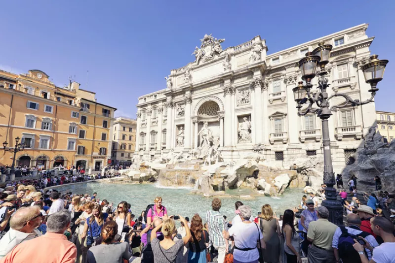 Tourists surrounding the Trevi Fountain in Rome