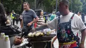 Un hombre vende elotes en la Alameda Central, frente al Palacio de Bellas Artes. 