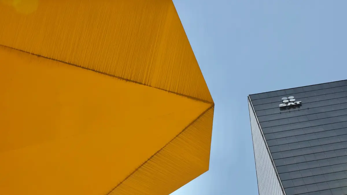 Vista de la fachada del edificio del SAT sobre Paseo de la Reforma, la perspectiva fotográfica también permite admirar parte de la escultura del Caballito del artista Sebastián. 