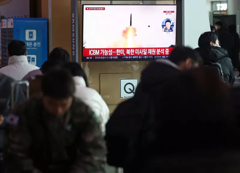 La gente ve una televisión que transmite un informe de noticias sobre Corea del Norte disparando lo que parecía ser un misil balístico de largo alcance, en una estación de tren en Seúl, Corea del Sur, el 18 de diciembre de 2023.