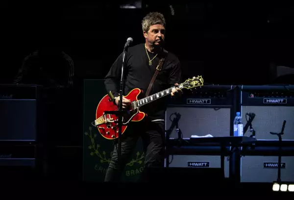 Foto de Noel Gallagher tocando su iconica guitarra roja durante el concierto de Oasis en México.