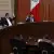 Sesión del tribunal electoral con una magistrada y tres magistrados alzando la mano. 